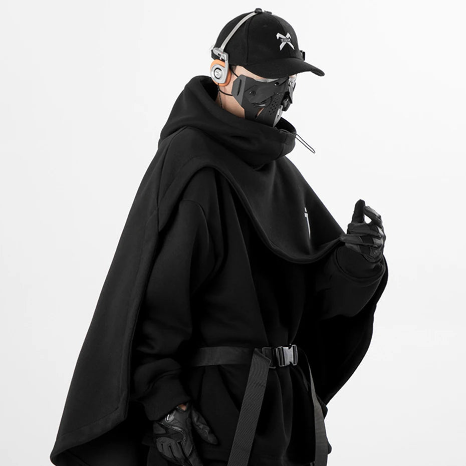 Cape hoodie techwear noire ARENS portée par un homme, style darkwear urbain avec casquette
