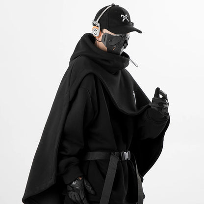 Cape hoodie techwear noire ARENS portée par un homme, style darkwear urbain avec casquette

