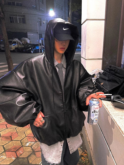 homme assis portant une veste en cuir PU noir oversize look urbain décontracté